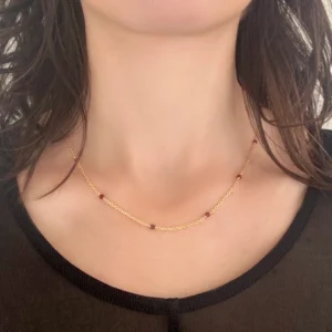 Verguld zilveren ketting met anker schakel en granaat steentjes aan hals gedragen