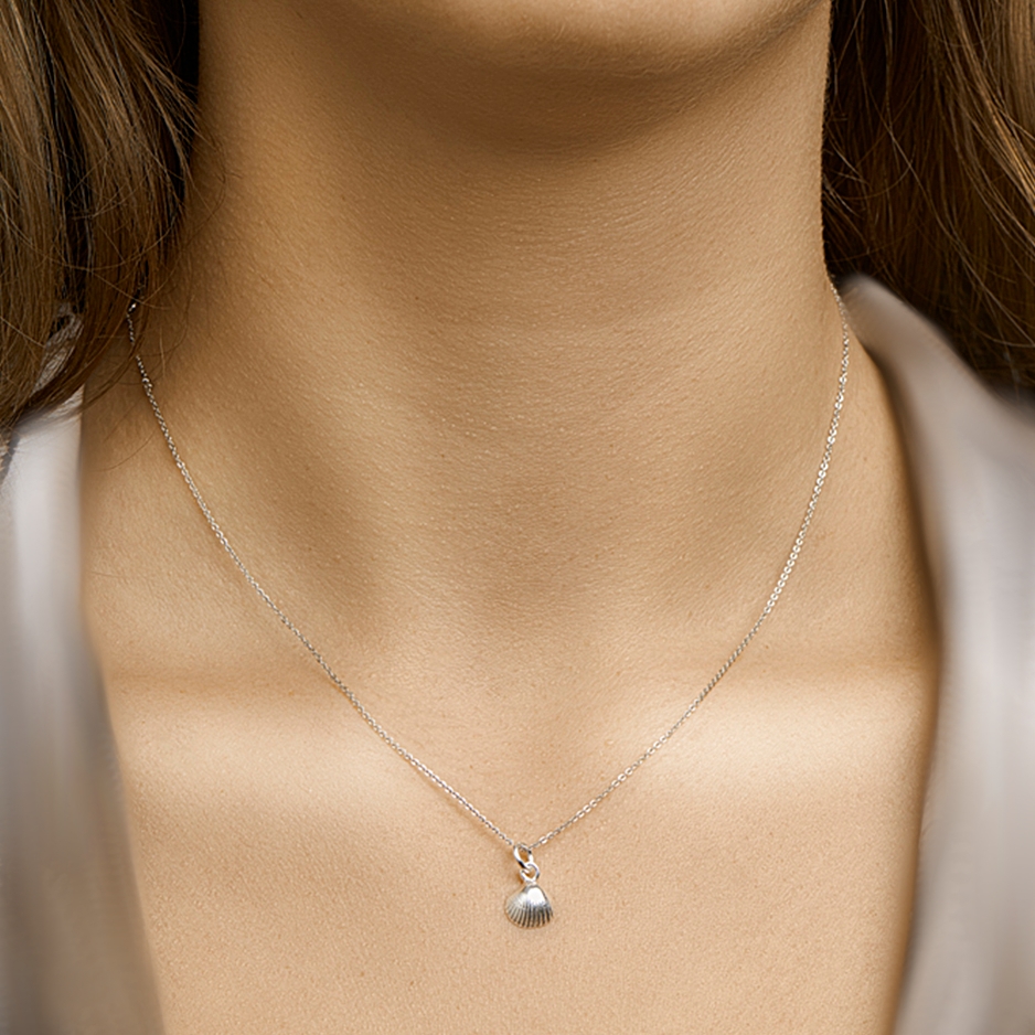 Zilveren ketting met schelp hanger aan de hals gedragen