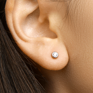 Zilveren oorknoppen met 4 mm zirkonia gedragen aan het oor