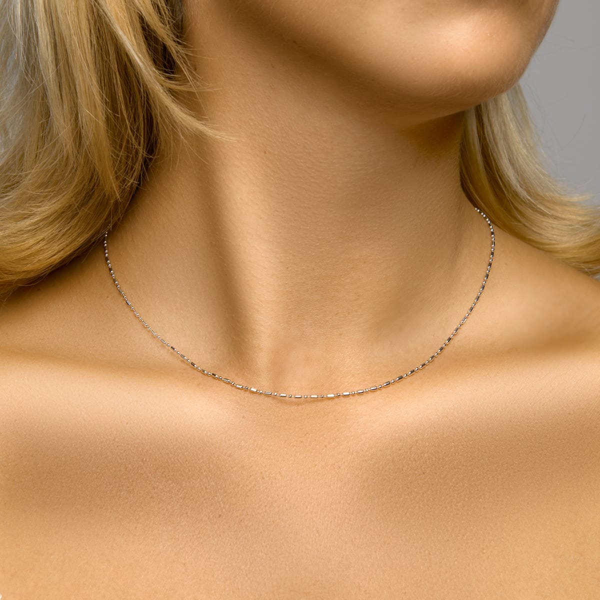Fijne gerhodineerde zilveren ketting van 925 Sterling zilver met een speels bolletjes- en staafjes patroon - gedragen